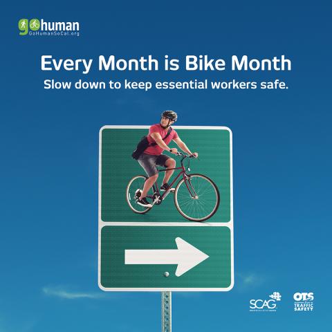 Cyclist on a road sign against a clear blue sky.